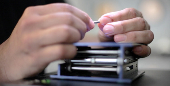 Worker Examines Screw