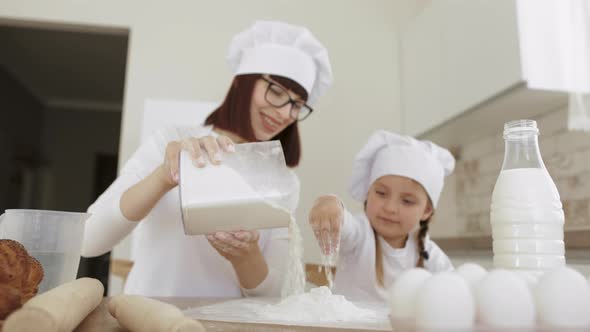 Happy Loving Family Scattering Flour From a Plastic Container While Preparing Bakery Together alt