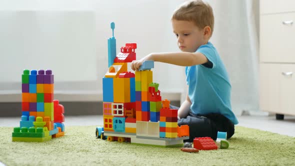 A Baby Boy Plays with Colored Blocks on a Floor