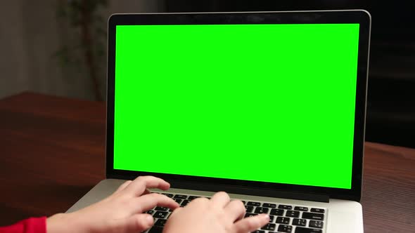 Over the Shoulder Little Boy Use Laptop with Green Screen Mockup on a Display alt