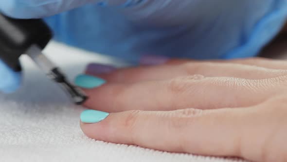 Young Woman Paints Her Nails with Protective Layer Base. Nails Manicure. 