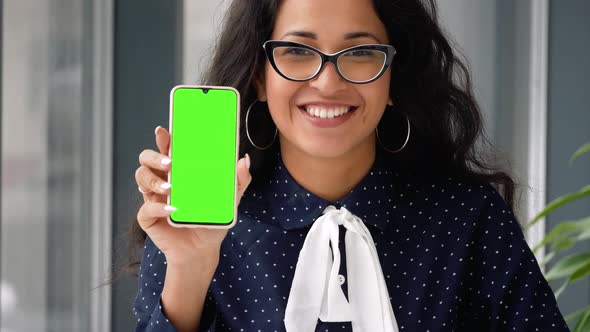 Happy mixed race businesswoman holding phone with chromakey. alt