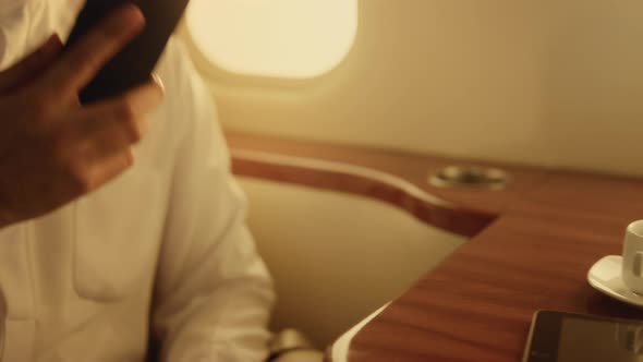 Arabian Businessman Talking Phone on Private Jet alt