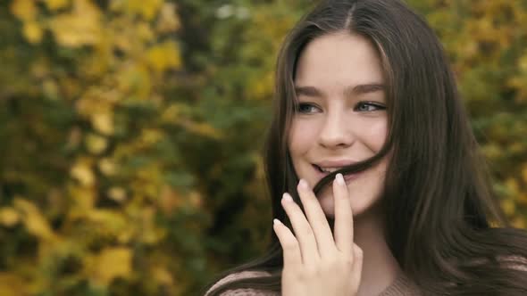 Portrait of Absolutely Happy Girl with Long Hair and Cute Smile in Park alt