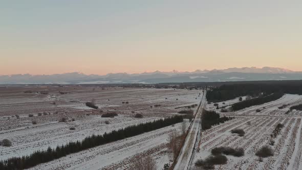 Sunset at winter rural landscape in Slovakia with distant mountains, aerial alt