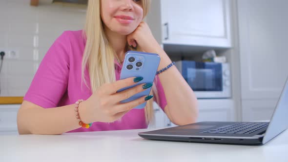 Blonde young woman using mobile phone for internet communication and entertainment alt