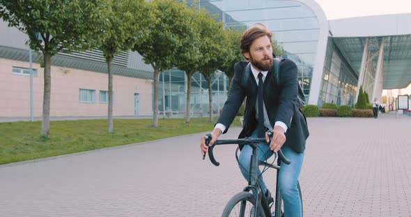 Businessman with Backpack in Formal Clothes Riding a Bicycle to His Office alt