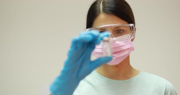 Doctor scientist with protective gloves and face mask holding vaccine medicine dose stock photo