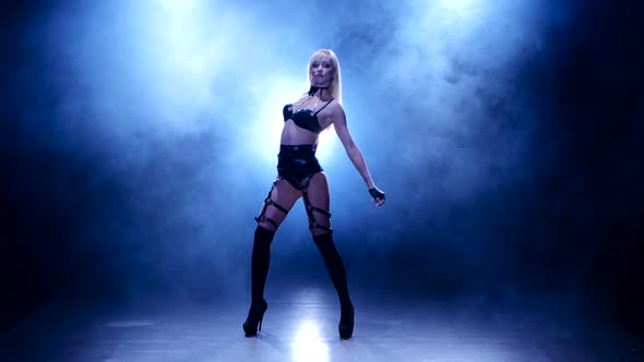 Young beautiful woman dancing modern dance on a blue background, strip dance. alt