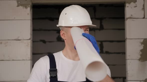 Portrait of a Male Architect with Drawings in His Hands on a Construction Site alt