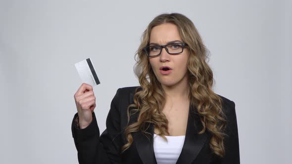 Girl Holds Credit Card and Takes Cash Choosing Between Them Nods Approvingly at Dollar Banknotes alt