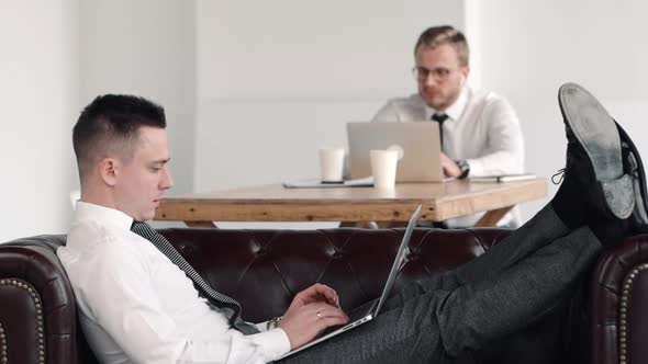 Businessman Lying Sit on Couch and Work with Colleague on Background. Solution, Thinking, Strategy