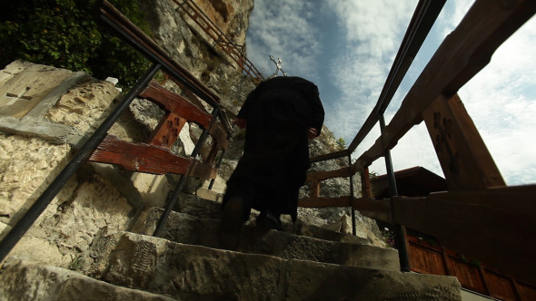 Monk Climbing Stairs To Old Church Made In Rock