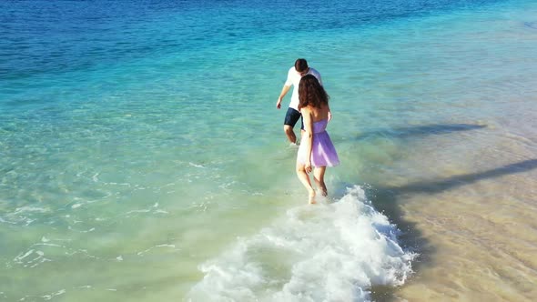 Teenage lovers in love on idyllic island beach time by blue lagoon and white sand background of Gili alt