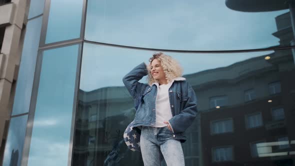 Portrait of a Beautiful Happy Curly Girl Outdoors. Cheerful Young Woman with a Charming Smile. alt