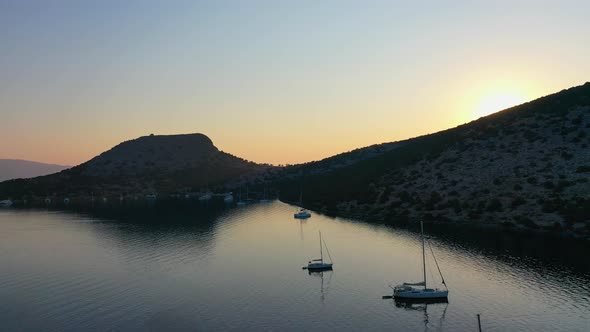 Catamaran and Sail Yachts Anchored at Bay on Deep Blue Sea Water on Sunrise alt