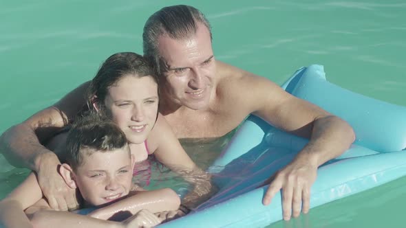 Father with two children relaxing in water