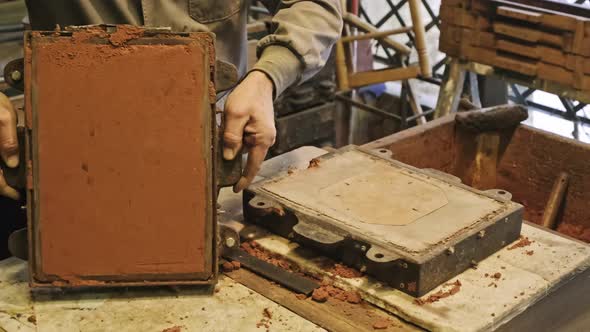 Craftsman producing metal casting manually in workshop alt