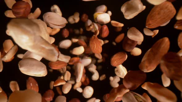 Super Slow Motion Closeup Shot of Falling Various Nuts Towards Camera on Black at 1000Fps alt