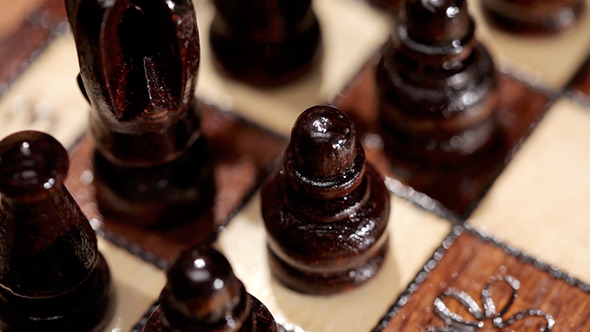 Black Chess Pieces On A Board alt