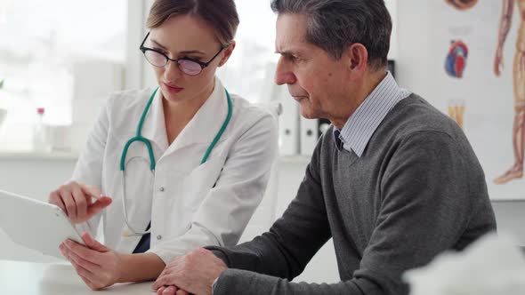 Handheld view of senior man having control visit in the doctor. Shot with RED helium camera in 8K alt