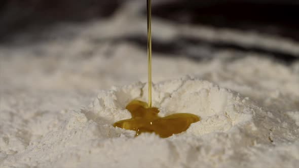 Vegetable Oil is Pouring in Flour Closeup in Slow Motion