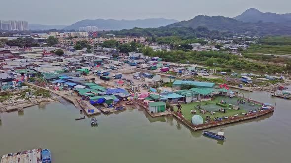A dynamic orbiting aerial footage of a seafood restaurant in the fishing village in Lau Fau Shan in alt