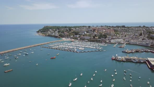 Aerial view of harbour town in southwest England. Flying over harbour in Brixham. Boats are docked. alt