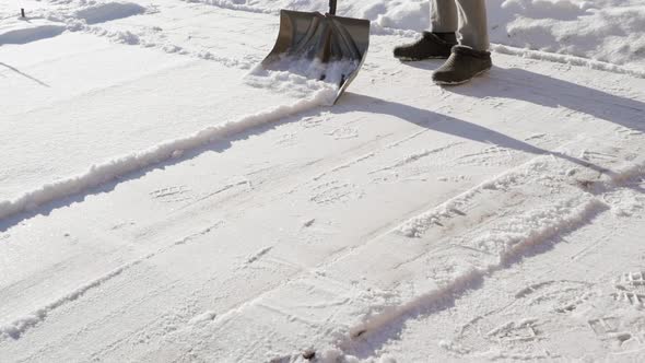 Calculating the Site on the Street From Snow with a Shovel on a Bright Sunny Day alt