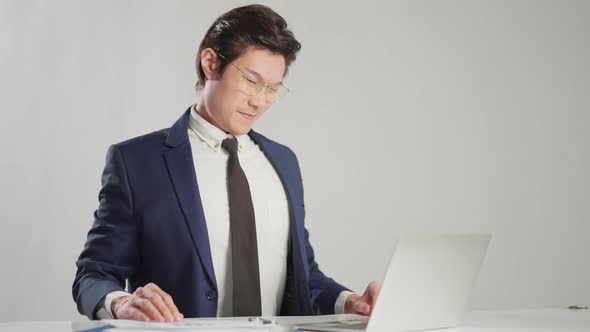 asian businessman wear formal suit sitting in office feeling body pain by office syndrome