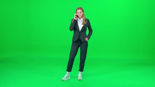 Businesswoman in a Suit Standing on Chroma Key Background Woman Using Smartphone and Talking on a alt