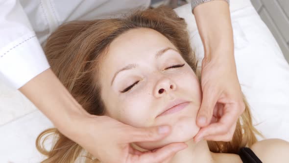 Cosmetologist Does Woman Facial Massage with Her Hands Relaxation and Pleasure Skin Correction