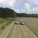 Aerial view of two Combines harvesting, trucks and tractor on grass field. 32 - VideoHive Item for Sale
