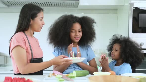 Asian-African American family Organize a birthday party for little sister in the kitchen