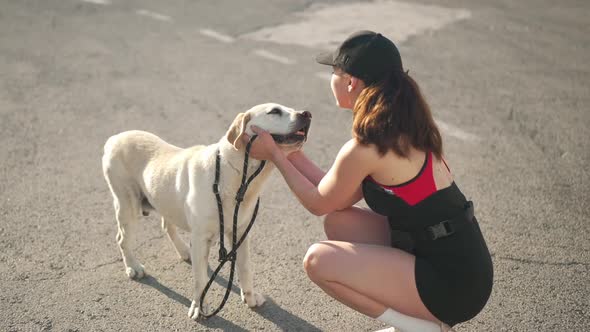 Happy Beige Labrador Wagging Tail As Young Woman Caressing Dog Head Talking in Slow Motion alt