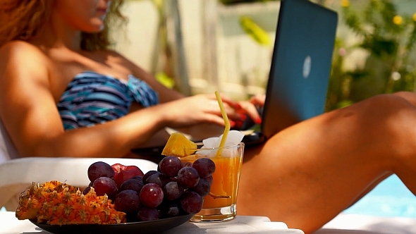 Woman Working on Laptop near Pool alt