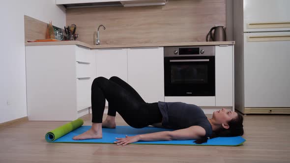 A Girl Exercise To Strengthen the Muscles of the Legs Lying on a Gymnastic Mat