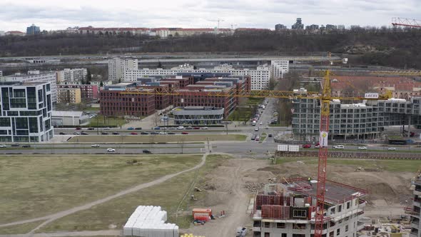 Tall tower cranes at construction site with car traffic, Prague city. alt