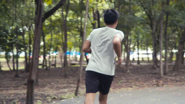 Handsome Asian man jogging in the public park.