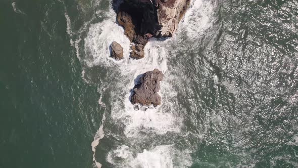 Bird's-eye view of Nazare Lighthouse and Fortress. Waves washing on rock and cliffs. alt