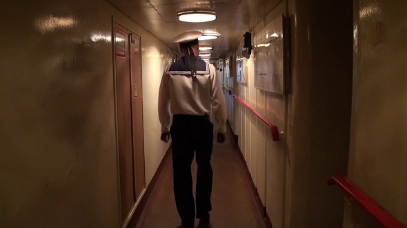 Sailor Passes Through the Ship Corridor