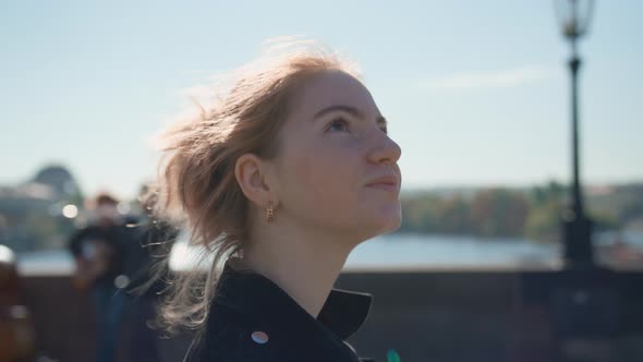 Young Woman Walking Along Sunny Charles Bridge alt