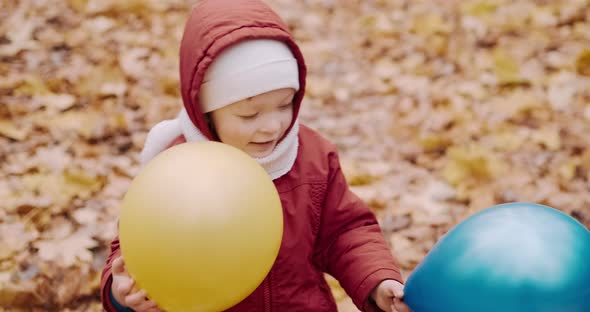 Small Child is Playing with His Mother in Inflatable Balloons