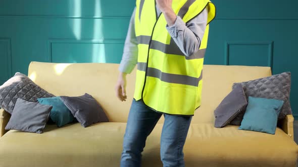 Architect Talking on the Phone and Sitting on Sofa to Relax After a Hard Day alt