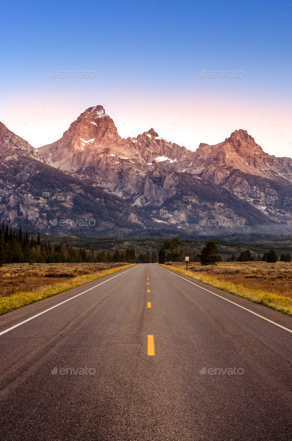 Scenic view of Grand Teton mountain range and road - Stock Photo - Images