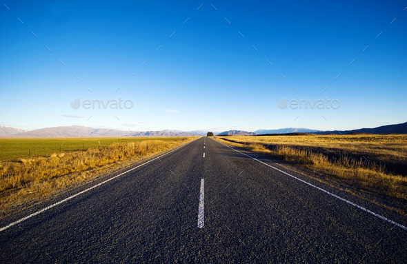Continuous Road In A Scenic With Mountain Ranges Afar - Stock Photo - Images