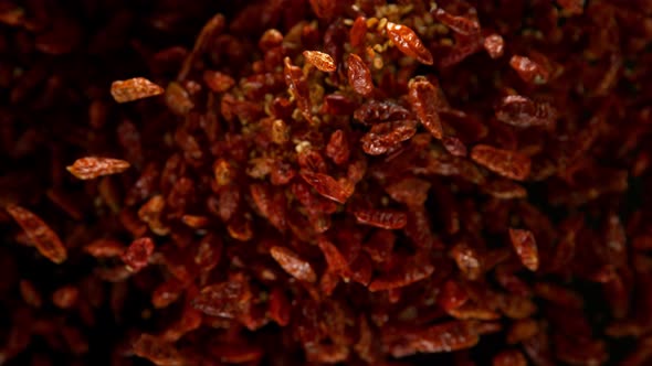 Super Slow Motion Shot of Dried Red Chili Peppers Explosion on Black Background at 1000Fps alt