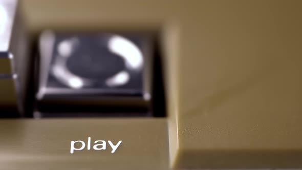 Finger Presses a Play Button of a Vintage Tape Recorder Macro alt