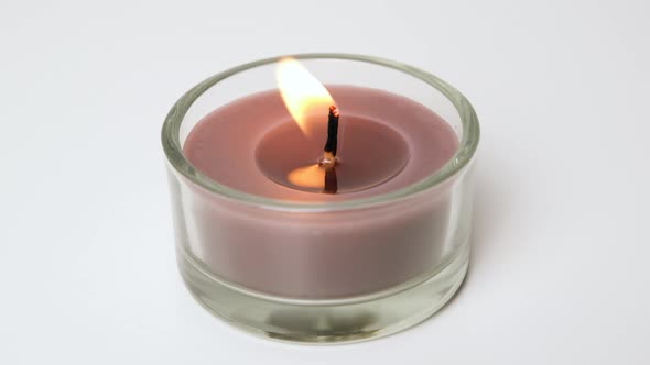 Round Brown Single Candle Flickering on White Background
