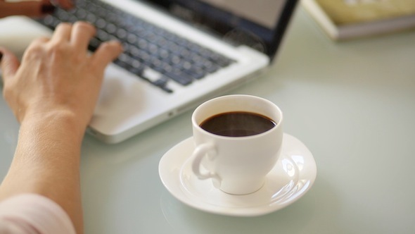 Woman Working With Laptop Drinking Coffee